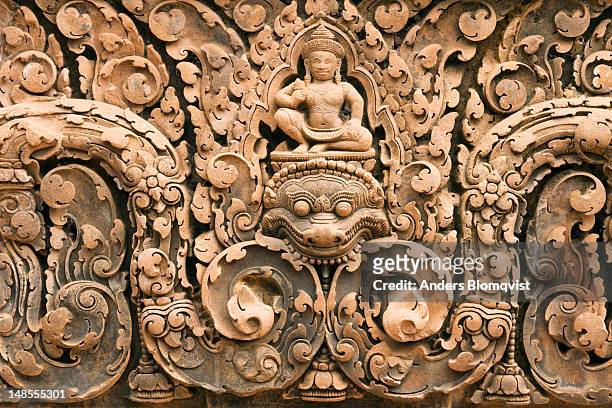 finely detailed sandstone carvings of indra atop a mythological kala at banteay srei temple. - banteay srei - fotografias e filmes do acervo