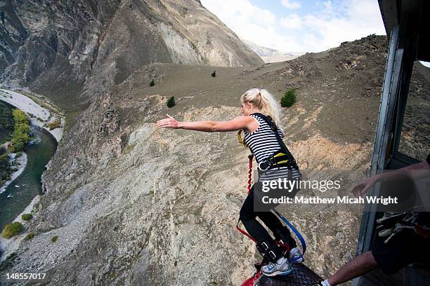 the nevis bungee is one of the most talked about activities in all of new zealand. the 134 meter jump from the center of the nevis bluff makes most people shake with fear before jumping and then beg for another jump after. the jump - bungee jump - fotografias e filmes do acervo