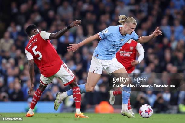 Erling Haaland of Manchester City beats Thomas Partey of Arsenal FC clash during the Premier League match between Manchester City and Arsenal FC at...