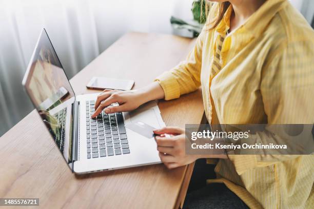 shot of pretty young woman shopping online with credit card and laptop while sitting on the floor at home. - phone credit card photos et images de collection