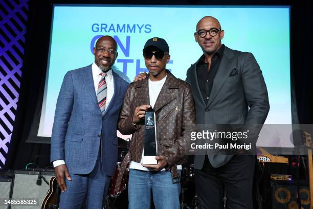 Honoree Pharrell Williams accepts his award from U.S. Senator Raphael Warnock and Harvey Mason Jr., CEO of the Recording Academy on stage during...