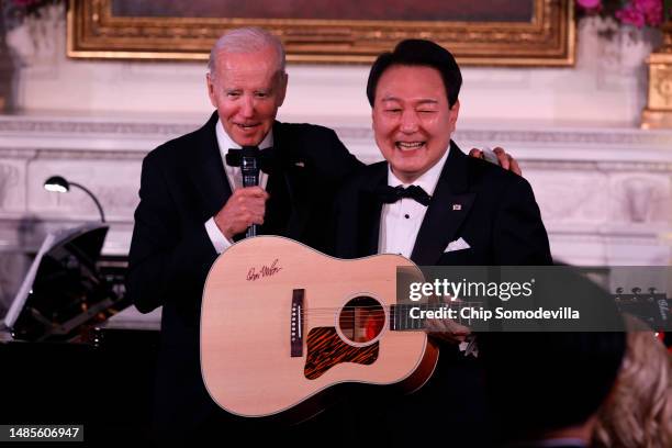President Joe Biden presents South Korean President Yoon Suk-yeol with a guitar signed by singer/songwriter Don McLean during a state dinner at the...