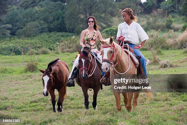 two women horse-riding, hotel hana-maui. - hotel hana maui stock pictures, royalty-free photos & images