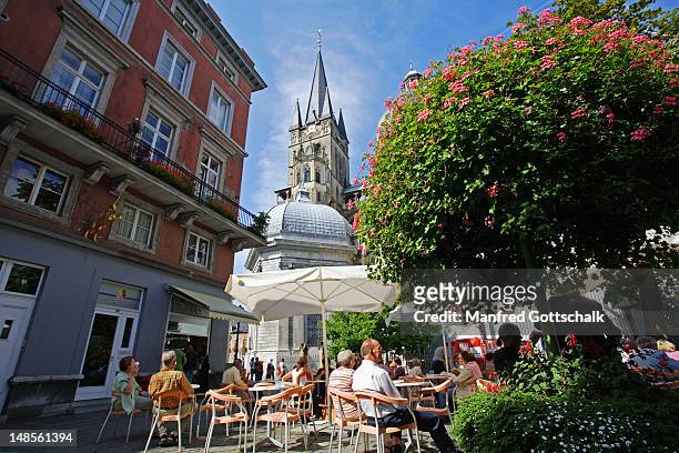 people relaxing at outdoor cafe in munsterplatz, near aachen dom (cathedral). - aachen photos et images de collection