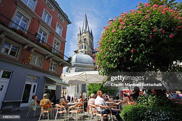 people relaxing at outdoor cafe in munsterplatz, near aachen dom (cathedral). - aachen stock pictures, royalty-free photos & images