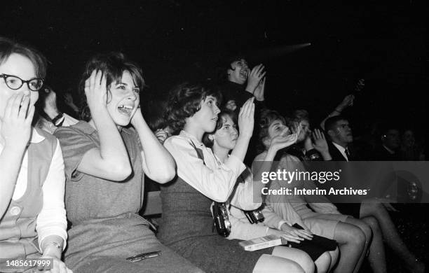 Fans, mostly women, react to a performance by the British rock group The Beatles, a Washington Coliseum in Washington, DC, February 11, 1964.