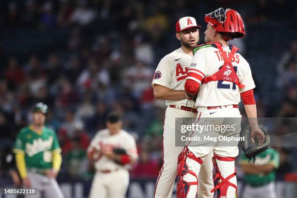 Chase Silseth and Matt Thaiss of the Los Angeles Angels meet on the mound in the eighth inning against the Oakland Athletics at Angel Stadium of...