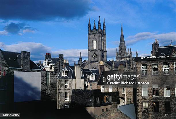 churches rise above buildings in the city centre. the building with the square tower now houses a pub called slain's castle. - aberdeen scotland stock pictures, royalty-free photos & images