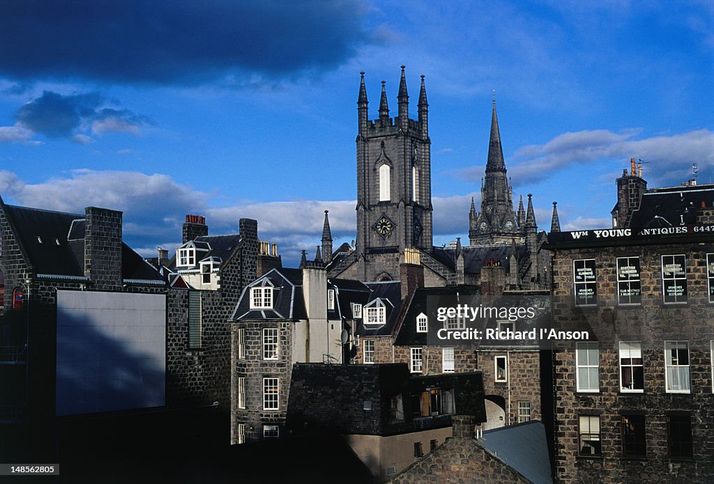 Churches rise above buildings in the city centre. The building with the square tower now houses a pub called Slain's Castle.