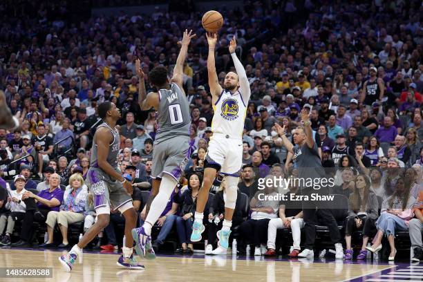 Stephen Curry of the Golden State Warriors shoots over Malik Monk and De'Aaron Fox of the Sacramento Kings during the second half of Game Five of the...