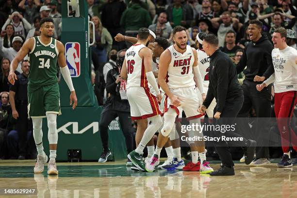 Max Strus and members of the Miami Heat celebrate in front of Giannis Antetokounmpo of the Milwaukee Bucks after winning Game 5 of the Eastern...