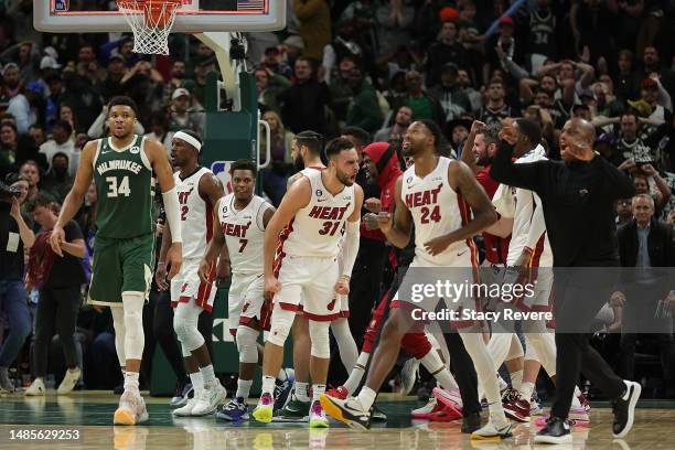 Max Strus and members of the Miami Heat celebrate in front of Giannis Antetokounmpo of the Milwaukee Bucks after winning Game 5 of the Eastern...