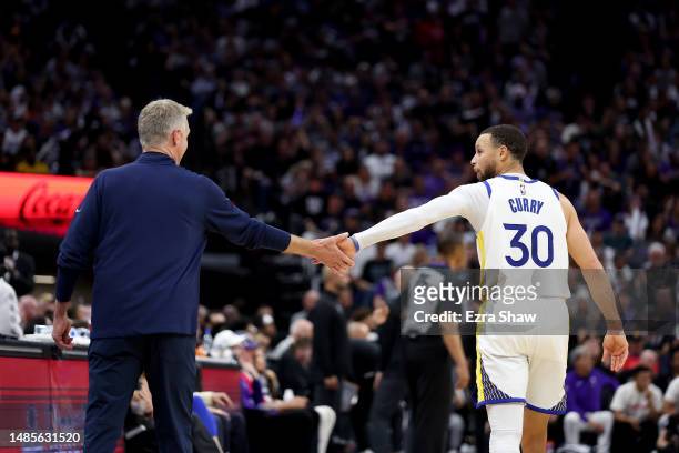 Stephen Curry of the Golden State Warriors slaps hands with head coach Steve Kerr during their game against the Sacramento Kings during the second...