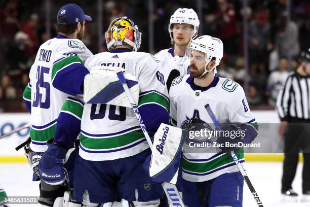 Conor Garland of the Vancouver Canucks celebrates with Collin Delia after a victory over the Arizona Coyotes at Mullett Arena on April 13, 2023 in...