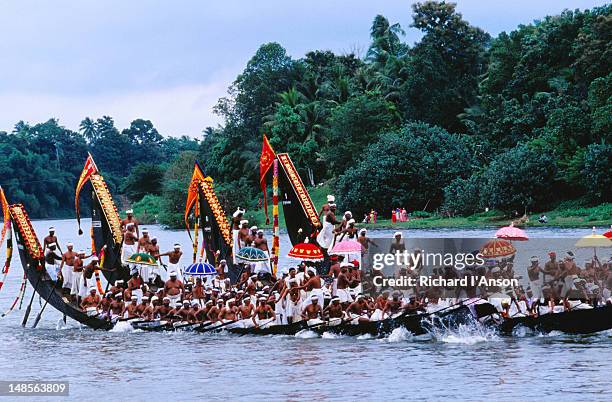 snake boats in pre-race procession on pampa river river during onam festival celebrations. - onam stock pictures, royalty-free photos & images