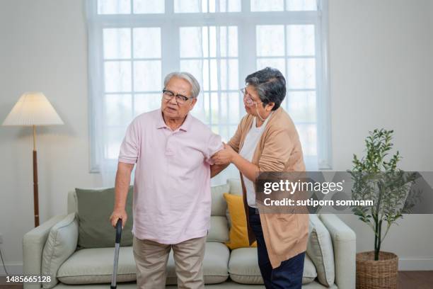 the senior woman helping a senior man  having back pain - back pain bed stock-fotos und bilder