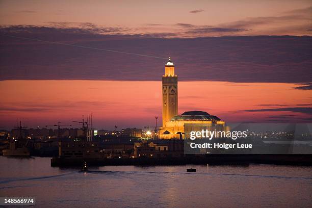 hassan ii mosque at sunset with laser beam pointing towards mecca. - casablanca photos et images de collection