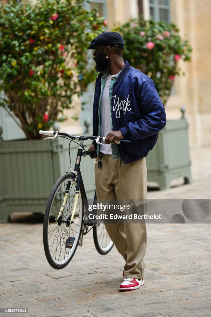 A guest wears a navy blue denim beret hat, gold and white pearls