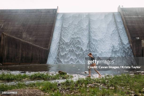 child crossing stream in front of waterfall spillway - lake marion stock pictures, royalty-free photos & images