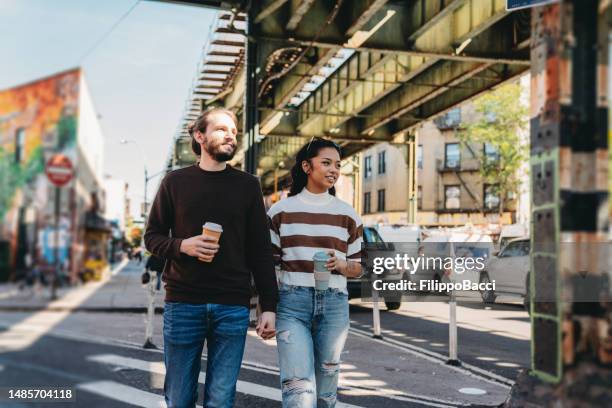 a millennial couple is walking together in brooklyn - couple crossing street stock pictures, royalty-free photos & images
