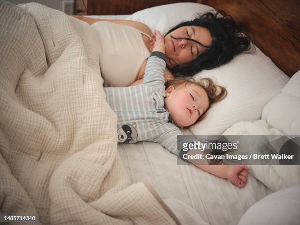 mother and daughter co sleeping in bed early in morning - cheveux au vent photos et images de collection