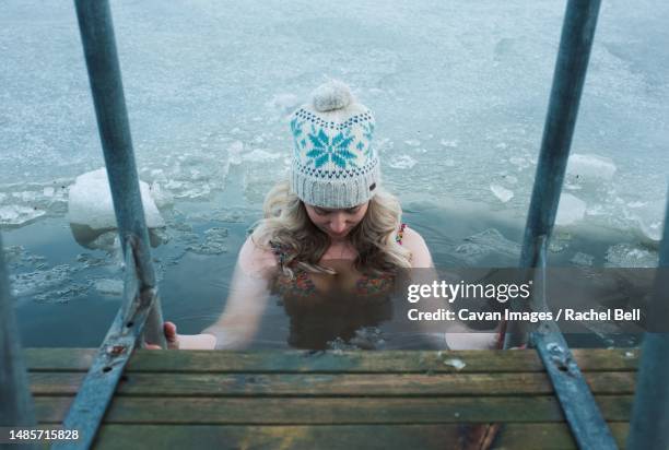 woman cold water swimming in the frozen baltic sea - 思い切って飛び込む ストックフォトと画像