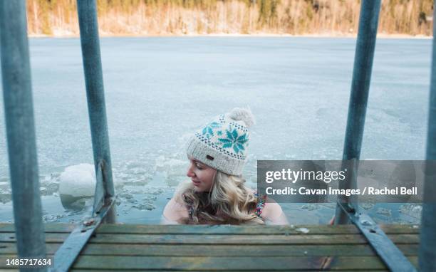 woman cold water swimming in the frozen baltic sea - kaltwasser stock-fotos und bilder