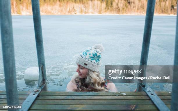 woman cold water swimming in the frozen baltic sea - eis baden stock-fotos und bilder