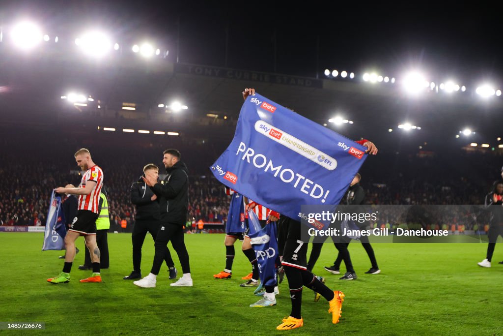 Rhian Brewster of Sheffield United lifts a banner reading 'PROMOTED