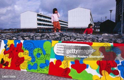 Inuit children playing in front of apartment buildings.