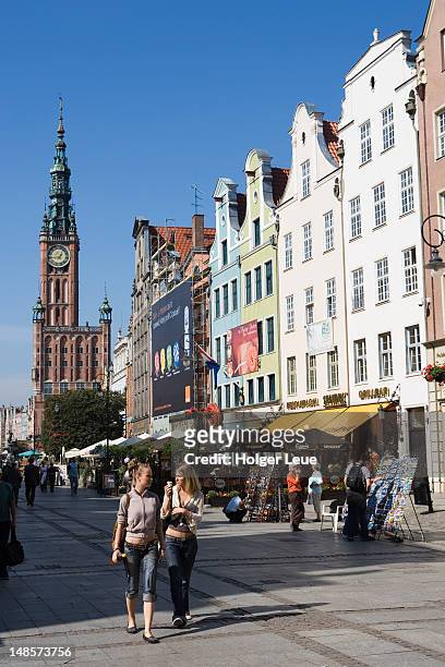 young women at long street market with gdansk town hall in background. - gdansk poland stock pictures, royalty-free photos & images