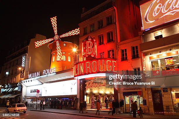 illuminated exterior of moulin rouge nightclub. - moulin rouge stock pictures, royalty-free photos & images