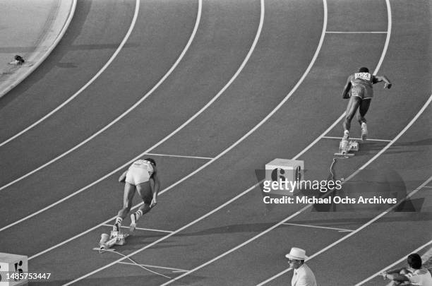 German athlete Harald Schmid and American athlete Edwin Moses leave the starting blocks in the final of the men's 400 metres hurdles event of the...
