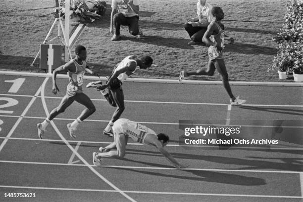Senegalese athlete Moussa Fall, Sudanese athlete Omer Khalifa behind British athlete Steve Ovett as he falls to the ground after finishing in fourth...