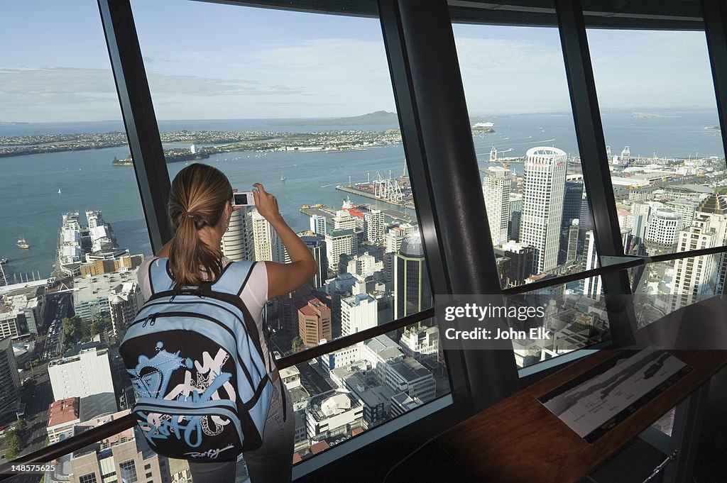 Young woman taking picture of city from Sky Tower.