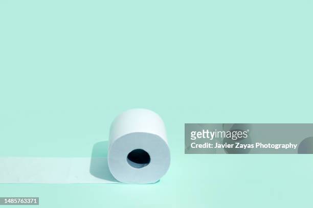 toilet roll on green background - roll up stock pictures, royalty-free photos & images