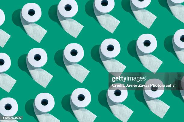 many toilet rolls on green background - gastroenteritis stock pictures, royalty-free photos & images