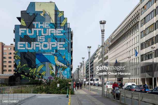 Residents walk past the famous graffiti mural painted by Belgian artist NovaDead, The Future is Europe, in the European quarter a few metres from the...