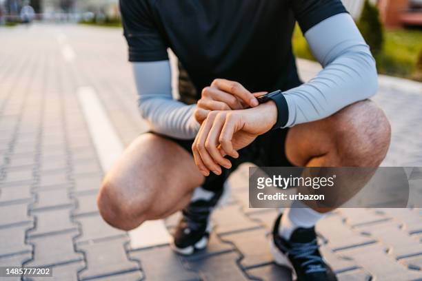 athlete checking fitness activity on fitness tracker after working out outdoors - pedometer stock pictures, royalty-free photos & images