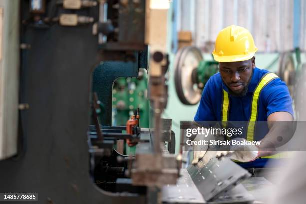 a worker works at a steel stamping plant. - precision metal stamping fotografías e imágenes de stock