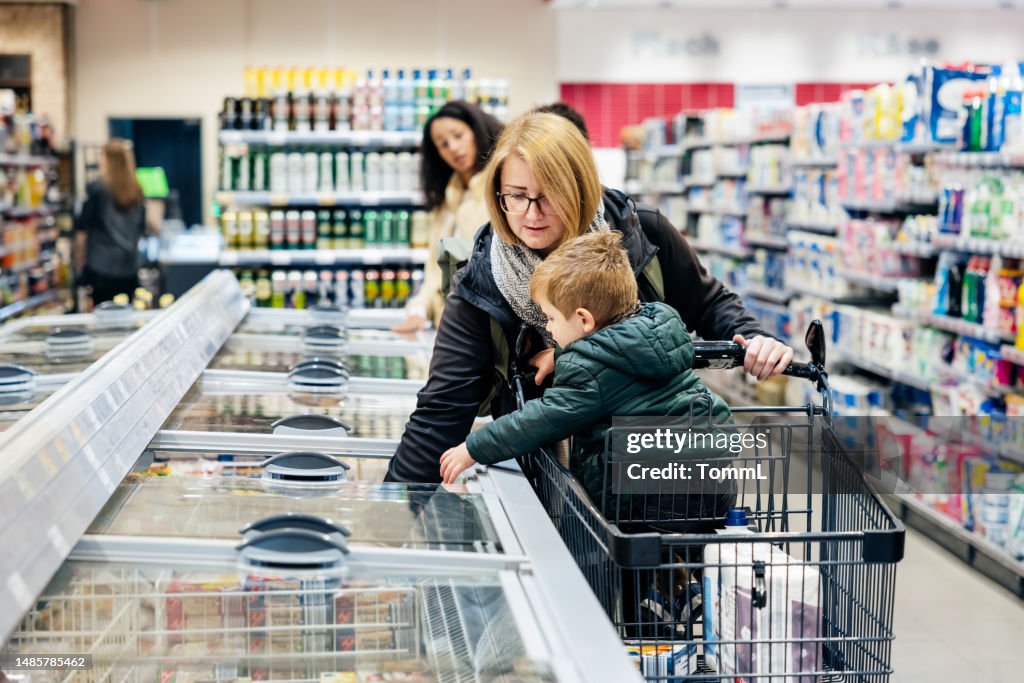 Mother Shopping For Groceries With Young Son In Kocal Supermarket