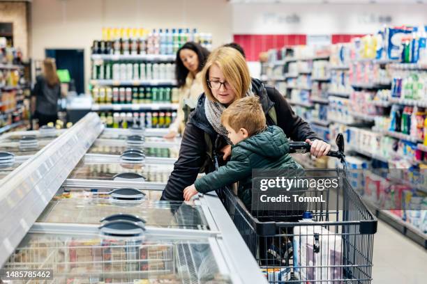 mother shopping for groceries with young son in kocal supermarket - frozen food stock pictures, royalty-free photos & images