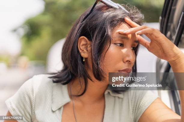 close up of worried woman next to broken car - frustrated workman stock pictures, royalty-free photos & images