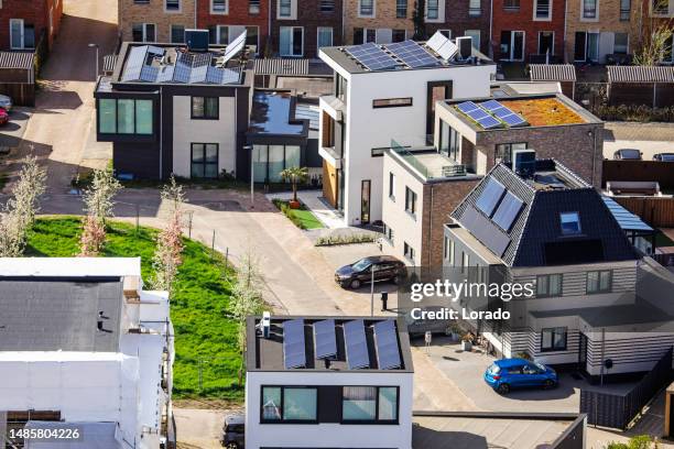 solar panels on residential housing rooftops in the netherlands - zonnepanelen stockfoto's en -beelden