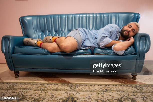 boy lying on sofa - bearded saki stock pictures, royalty-free photos & images