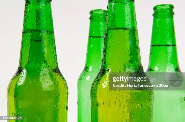 close-up of beer bottles against white background,romania - bottle condensation stock pictures, royalty-free photos & images