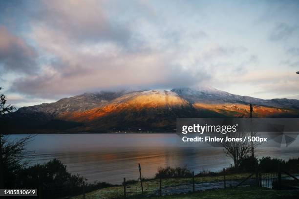 scenic view of lake by mountains against sky,illuminated by the sunrise,united kingdom,uk - satoyama scenery stock pictures, royalty-free photos & images
