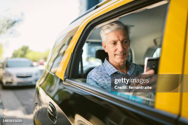 businessman using smartphone during a taxi ride - uber in buenos aires argentina stock pictures, royalty-free photos & images