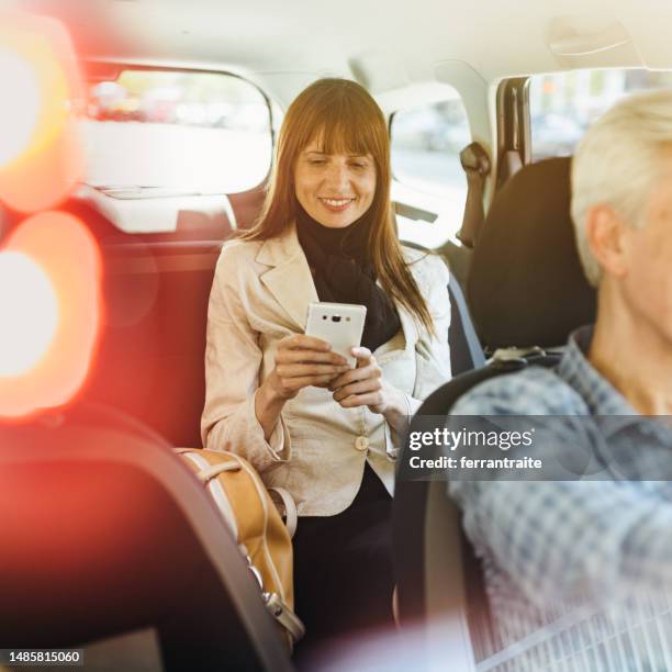 businesswoman using smartphone during a taxi ride - uber in buenos aires argentina stock pictures, royalty-free photos & images