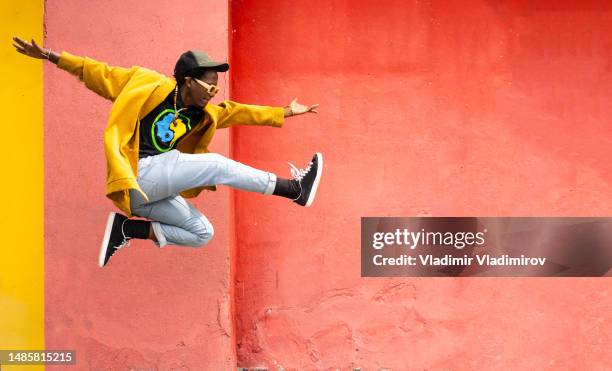 foto de cuerpo entero de un chico multiétnico salvaje saltando alto - esfuerzo fotografías e imágenes de stock